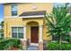 Front entrance of a yellow townhome with columns and a manicured landscape at 519 Sandstone St, Lakeland, FL 33809