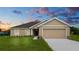 Tan-colored house with a two-car garage and landscaped lawn at 840 Voight N Ave, Fort Meade, FL 33841