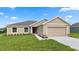 Tan house with a two-car garage and landscaping at 840 Voight N Ave, Fort Meade, FL 33841