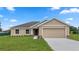 Tan house with a two-car garage and landscaping at 840 Voight N Ave, Fort Meade, FL 33841