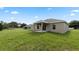 Tan house with covered patio and grassy backyard at 840 Voight N Ave, Fort Meade, FL 33841