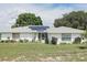 White brick ranch house with solar panels, landscaping, and spacious lawn at 152 Audubon Ct, Winter Haven, FL 33884