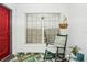 Bright front entry with red door, rocking chair, and tropical rug at 152 Audubon Ct, Winter Haven, FL 33884