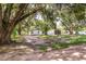 View of house exterior, driveway, and large oak trees at 2531 Hebb Rd, Auburndale, FL 33823