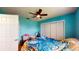 Bedroom with light teal walls, ceiling fan, and double closet at 2423 State Road 557, Lake Alfred, FL 33850