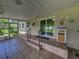 Spacious screened porch with tiled flooring, access to the home, and ceiling fans at 431 Longfellow Blvd, Lakeland, FL 33801