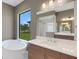 Luxurious bathroom with soaking tub, double vanity, and a view of the backyard at 1969 Grasslands Blvd, Lakeland, FL 33803