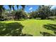 Large grassy backyard with mature trees and home view at 7520 Kathleen Rd, Lakeland, FL 33810