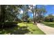 Landscaped front yard with driveway and mature trees at 7520 Kathleen Rd, Lakeland, FL 33810