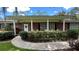 Brick house with covered porch, lush landscaping, and a curved walkway at 7520 Kathleen Rd, Lakeland, FL 33810