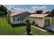 House exterior featuring a stone chimney, attached garage and manicured lawn at 2508 Providence Rd, Lakeland, FL 33805