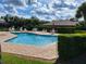 Community pool with lounge chairs and umbrellas at 727 Martinique Cir, Lakeland, FL 33803