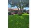 Brick house with lush lawn and large shade tree at 727 Martinique Cir, Lakeland, FL 33803