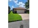 Attached garage with paved driveway and lush lawn at 727 Martinique Cir, Lakeland, FL 33803