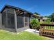 Backyard view of home with screened porch and wooden bench at 727 Martinique Cir, Lakeland, FL 33803