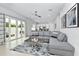Bright living room with gray sectional sofa and sliding doors to patio at 7770 Sandy Ridge Dr # 115, Reunion, FL 34747