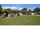 Tan single-story house with a large yard, double doors, and a white garage door at 2646 Handley Blvd, Lakeland, FL 33803
