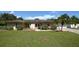 Tan single-story house with a large yard, double doors, and a white garage door at 2646 Handley Blvd, Lakeland, FL 33803