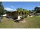 Side view of a tan house with palm trees and a chain link fence at 2646 Handley Blvd, Lakeland, FL 33803