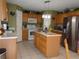 Open kitchen with island and stainless steel refrigerator at 600 Sunway Ln, Winter Haven, FL 33880