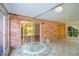 Cozy screened porch with brick walls and glass sliding door access to the interior at 832 S Hill Ave # 10, Deland, FL 32724