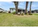 Home's backyard features a screened patio, landscaping, and spacious lawn at 2636 Huntington Hills Dr, Lakeland, FL 33810