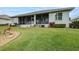 House's back features a screened porch, manicured lawn, and mature trees at 2636 Huntington Hills Dr, Lakeland, FL 33810