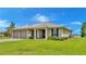 Single-story house featuring a two-car garage and a manicured lawn at 7884 N Lake Buffum Shores Rd, Fort Meade, FL 33841