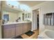 Modern bathroom with double vanity, a large mirror, and a walk-in closet at 1268 Pintail Pl, Lakeland, FL 33813