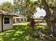Landscaped backyard with lush lawn, large tree, and patio area at 1323 Hammock Shade Dr, Lakeland, FL 33809