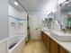 Clean bathroom, featuring a bathtub, double vanity, and updated tile at 1323 Hammock Shade Dr, Lakeland, FL 33809