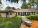 Tan house exterior with patio and lush landscaping at 1323 Hammock Shade Dr, Lakeland, FL 33809