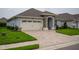 Single-story home with paver driveway and landscaped yard at 7914 Lake James Blvd, Lakeland, FL 33810