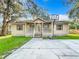 Beige house with front porch, basketball hoop, and yard at 110 Berry Rd, Winter Haven, FL 33880