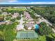 Aerial view of a community with houses, a pool, and tennis court at 665 Lake Clark Pl, Lakeland, FL 33813