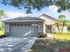 Single-story home with gray siding, two-car garage, and landscaping at 665 Lake Clark Pl, Lakeland, FL 33813