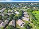 Aerial view of a community with houses, lush greenery, and a lake in the background at 665 Lake Clark Pl, Lakeland, FL 33813
