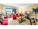 Living room with red couch, lake view, and patio access at 1920 E Edgewood Dr # G5, Lakeland, FL 33803