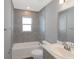 Bathroom with gray tile, a bathtub, and a vanity with a white countertop at 1882 Daystar Dr, Haines City, FL 33844