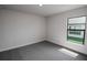 Well-lit bedroom featuring grey carpet and large window at 4544 Grand View Glen Dr, Auburndale, FL 33823
