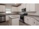 Modern kitchen with white cabinets, granite counters and island at 4544 Grand View Glen Dr, Auburndale, FL 33823