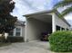 House with carport and a red SUV parked inside at 323 Travelers Dr, Polk City, FL 33868