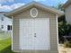 White double-door storage shed in the backyard at 323 Travelers Dr, Polk City, FL 33868