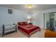 Cozy bedroom with a double bed, crib, and access to a bathroom at 103 Coventry Ln, Haines City, FL 33844
