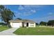 One-story house with a white garage door and a spacious lawn at 522 Raymond Ave, Frostproof, FL 33843