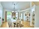 Elegant dining room with a white table and chairs, hardwood floors, and arched windows at 3258 Triple Crown Ln, Lakeland, FL 33811