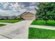 Tan one-story house with a two-car garage at 653 Hidden Lakes Ct, Haines City, FL 33844