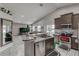 Modern kitchen with breakfast bar, stainless steel appliances, and tile flooring at 653 Hidden Lakes Ct, Haines City, FL 33844