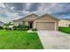 Tan one-story house with a two-car garage at 653 Hidden Lakes Ct, Haines City, FL 33844