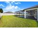 Large backyard with grassy lawn and a screened pool at 5017 Ridgefield Lane, Lakeland, FL 33812